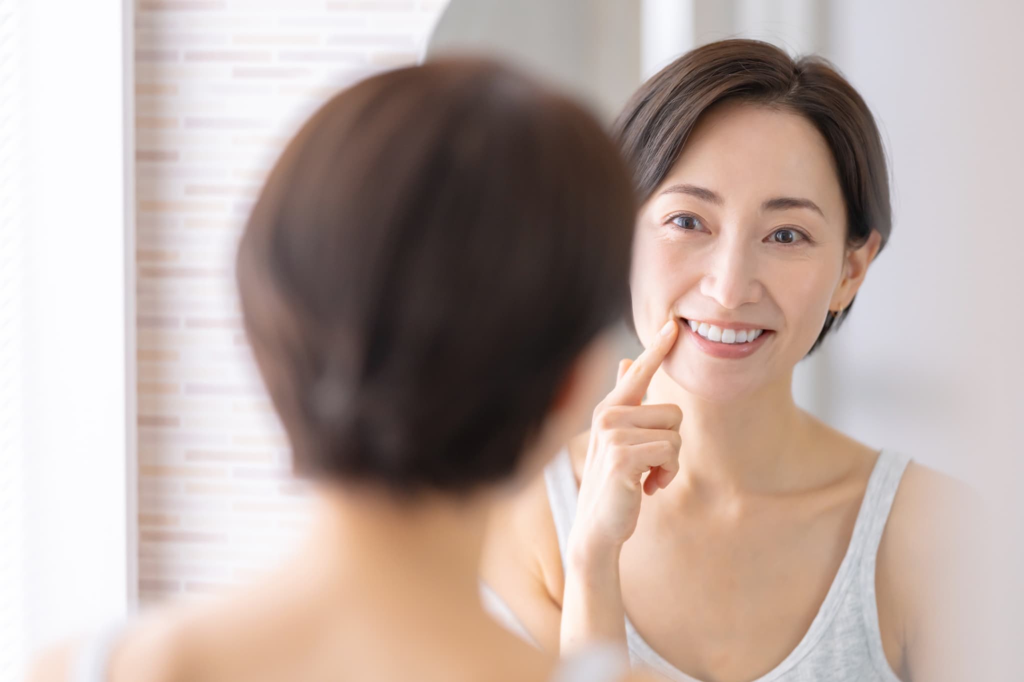 奥歯の虫歯を予防し鏡で歯をチェックする女性