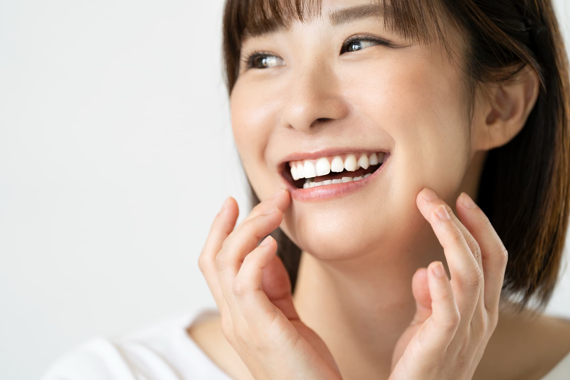 口元に手を当てて微笑む女性