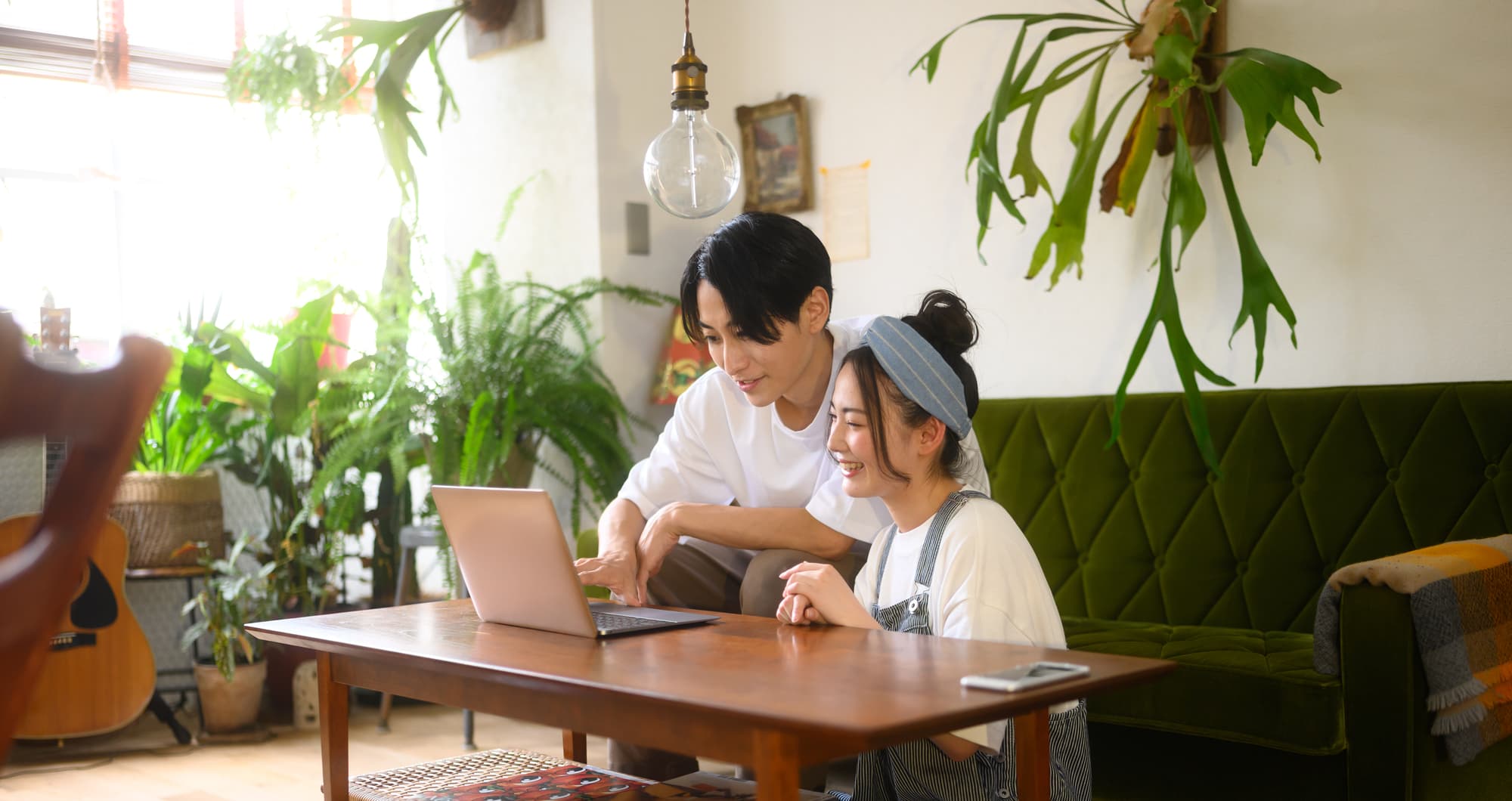 楽しそうにパソコンで動画を見る男女