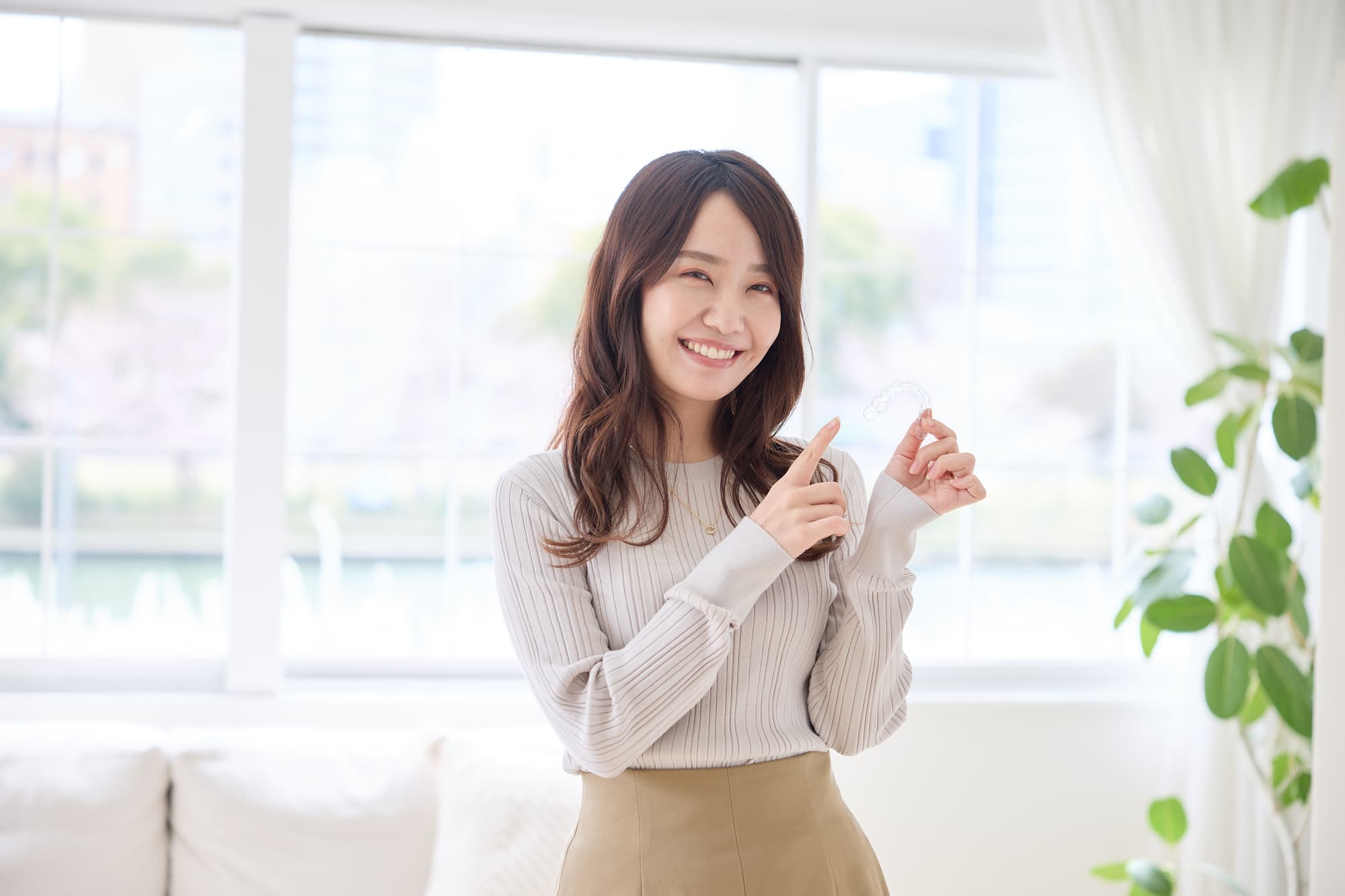 マウスピースを持ち指さす女性