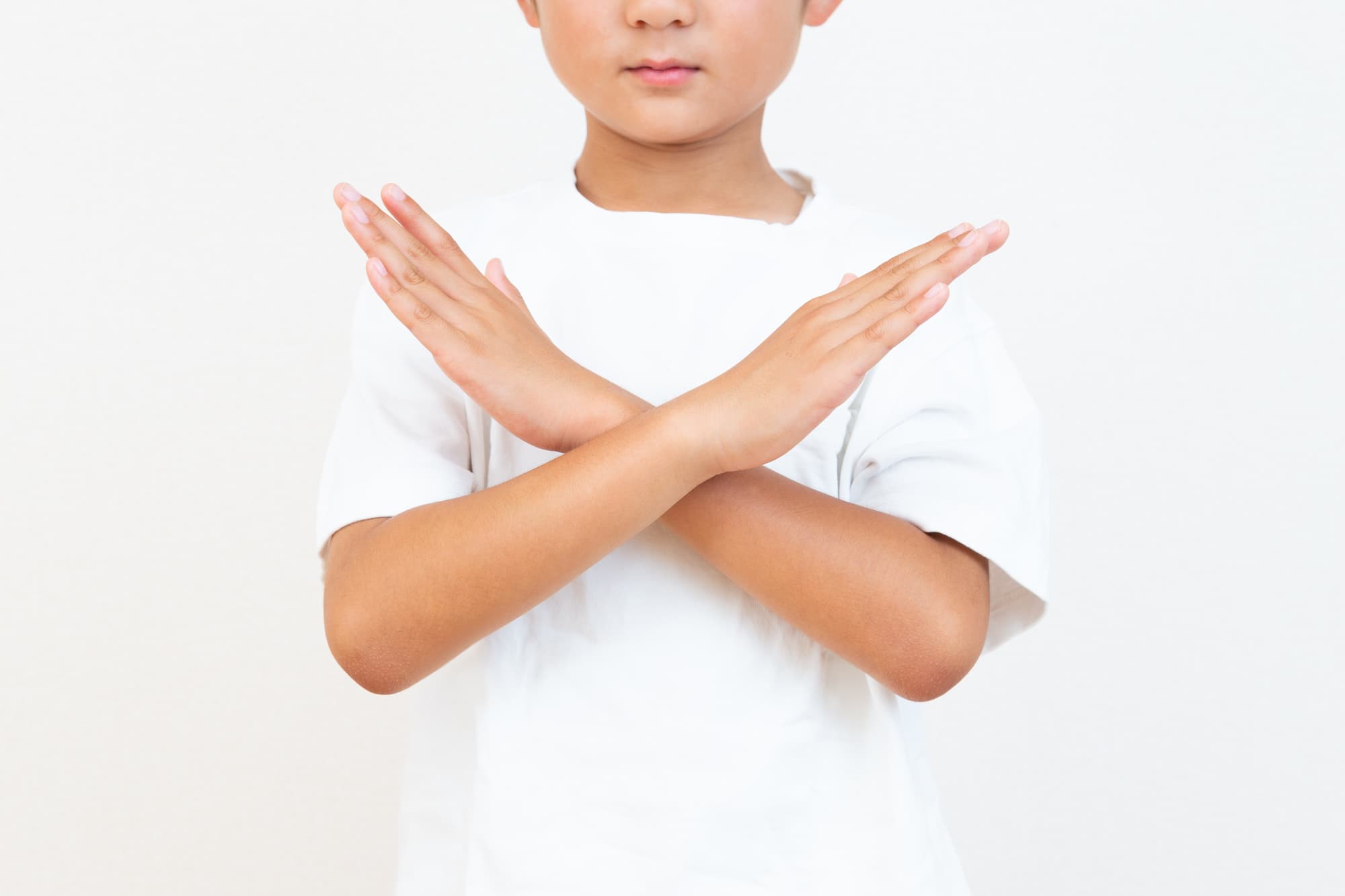 腕でバツ印を作る子ども