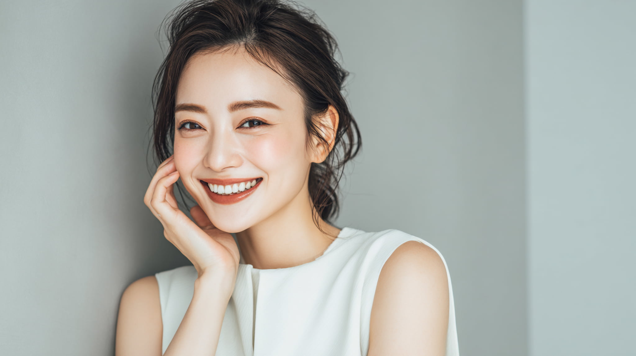 ホワイトニングした白い歯に満足して微笑む女性