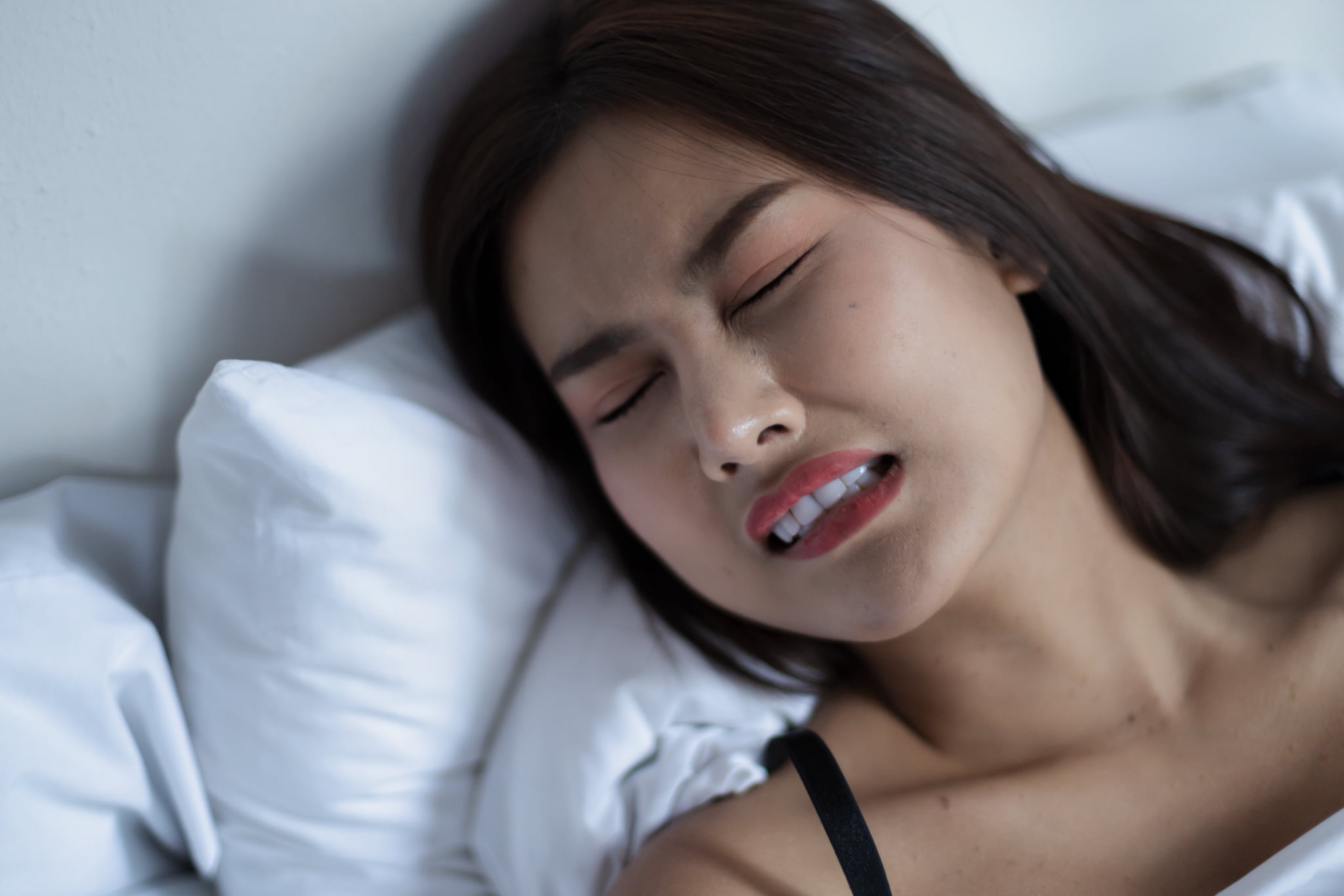 歯ぎしりしながら眠っている女性